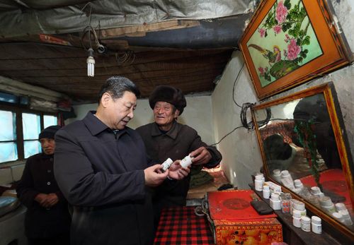 2012年12月30日，習近平在龍泉關鎮駱駝灣村困難群眾唐榮斌家，詳細詢問身體有病的唐榮斌（右）日常服藥情況。