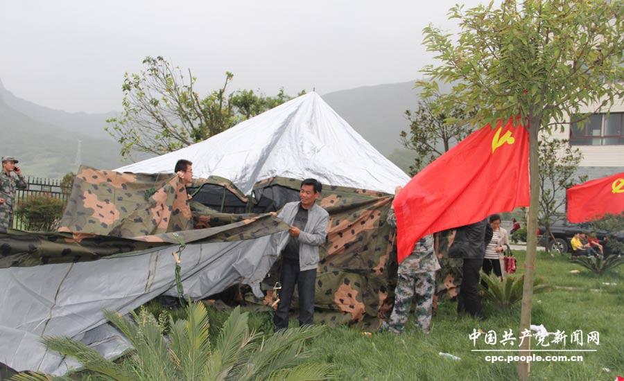 黨員干部在龍門鄉安置點幫助群眾搭建帳篷