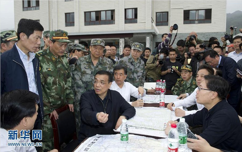 20日下午，在重災區龍門鄉政府前的空地上，李克強召開了現場會，聽取當地干部的匯報。他說，重要的是保証今天晚上有帳篷住，同時要注意防止次生災害造成新的傷亡。得知寶興縣已與外界中斷了聯系，他當即要求救災部隊和相關部門盡全力打通道路、恢復通信。新華社記者 黃敬文 攝