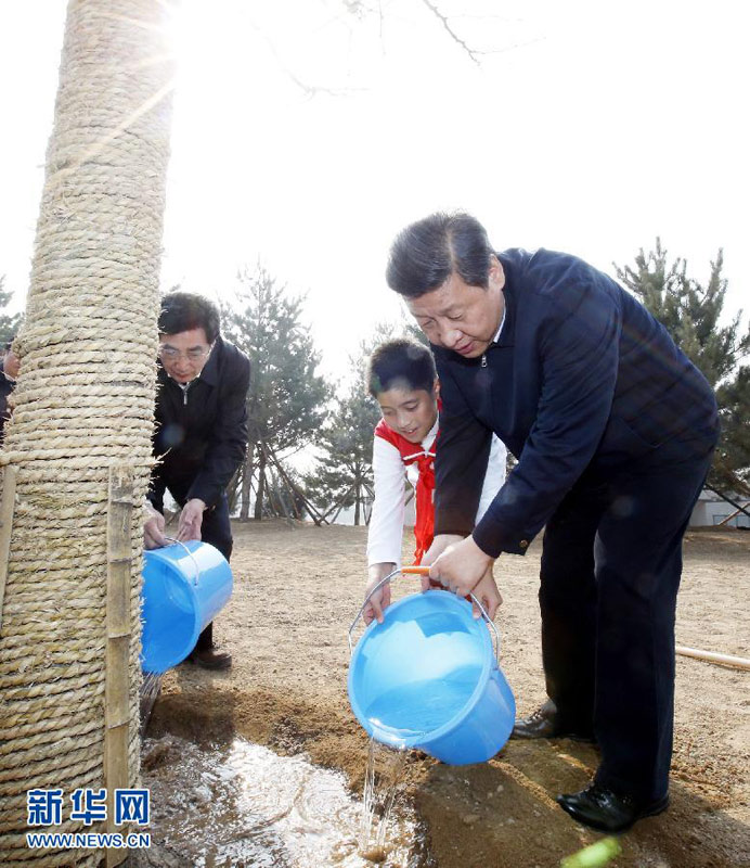 2013年4月2日，黨和國家領導人來到北京市豐臺區永定河畔參加首都義務植樹活動。這是習近平同少先隊員一起給剛栽下的銀杏樹澆水。新華社記者 鞠鵬 攝