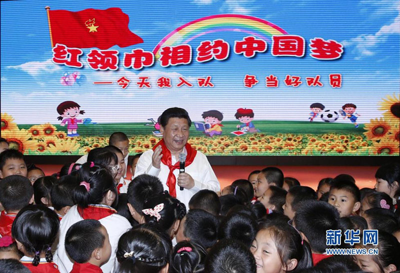 2014年5月30日上午，習近平來到北京市海澱區民族小學，參加慶?！傲弧眹H兒童節活動。這是習近平在參加少先隊入隊儀式時，向少先隊員們致以節日問候。新華社記者 鞠鵬 攝