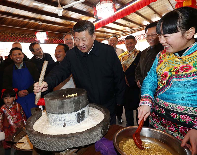 這是2月12日上午，習近平在阿壩藏族羌族自治州汶川縣映秀鎮考察時同居民群眾一起磨豆花。 新華社記者 鞠鵬 攝