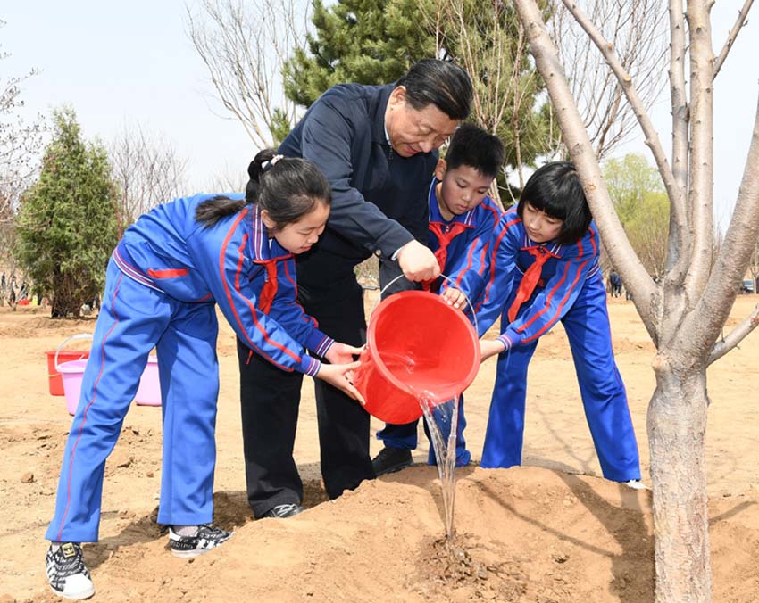 4月8日，黨和國家領導人習近平、栗戰書、汪洋、王滬寧、趙樂際、韓正、王岐山等來到北京市通州區永順鎮參加首都義務植樹活動。這是習近平同少先隊員一起給剛栽下的樹苗澆水。新華社記者 謝環馳 攝