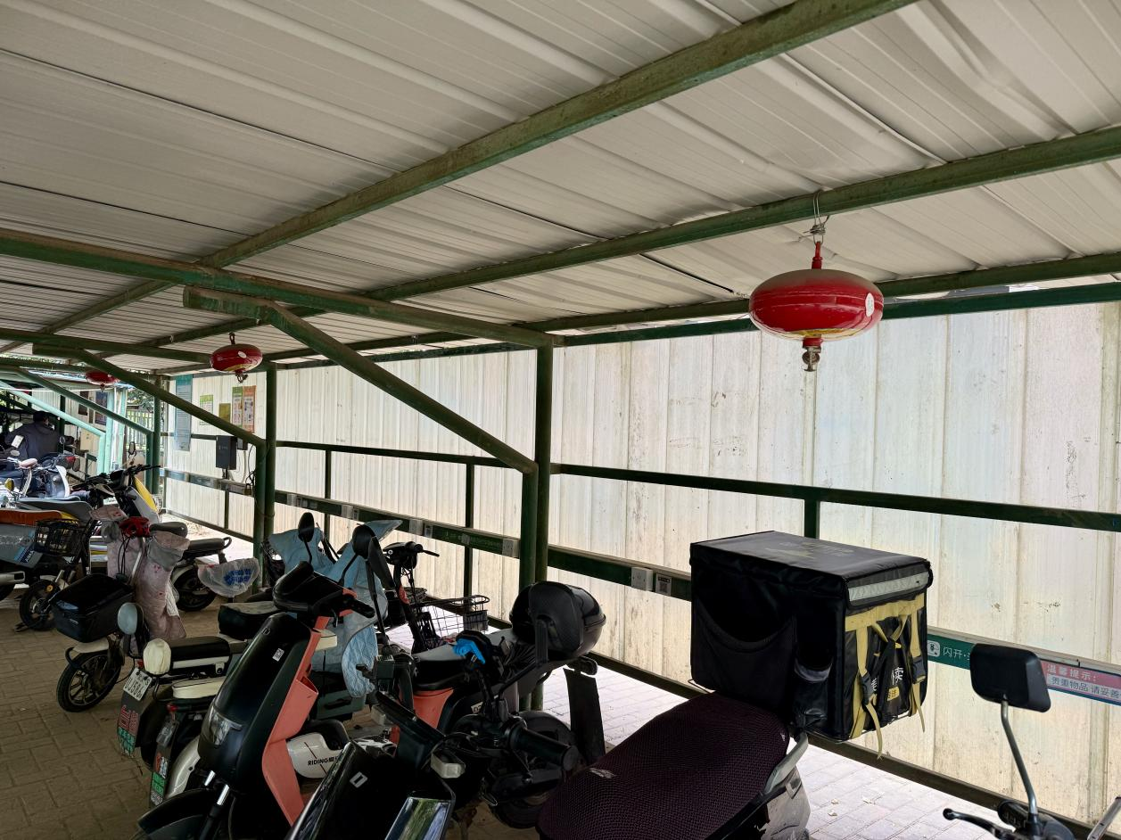 青和居小區電動車棚配備了懸掛式溫感滅火器。人民網記者 周恬攝