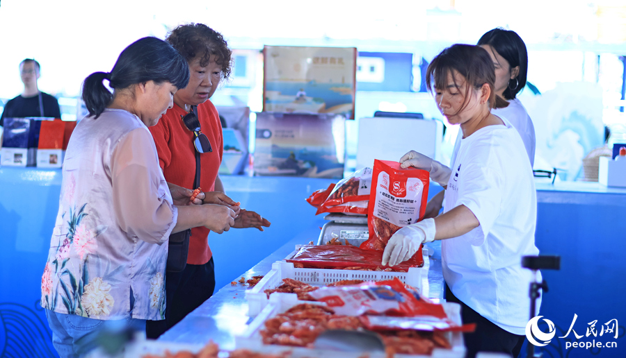 游客在澳角村采購當地海鮮加工產品。人民網 李昌乾攝