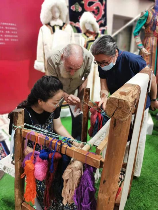 楊永良的學生在展會上向客商介紹加牙藏毯編織技藝。受訪者供圖